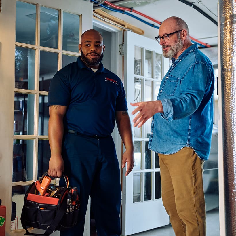 A Snell technician discusses the repair and installation services with a homeowner.