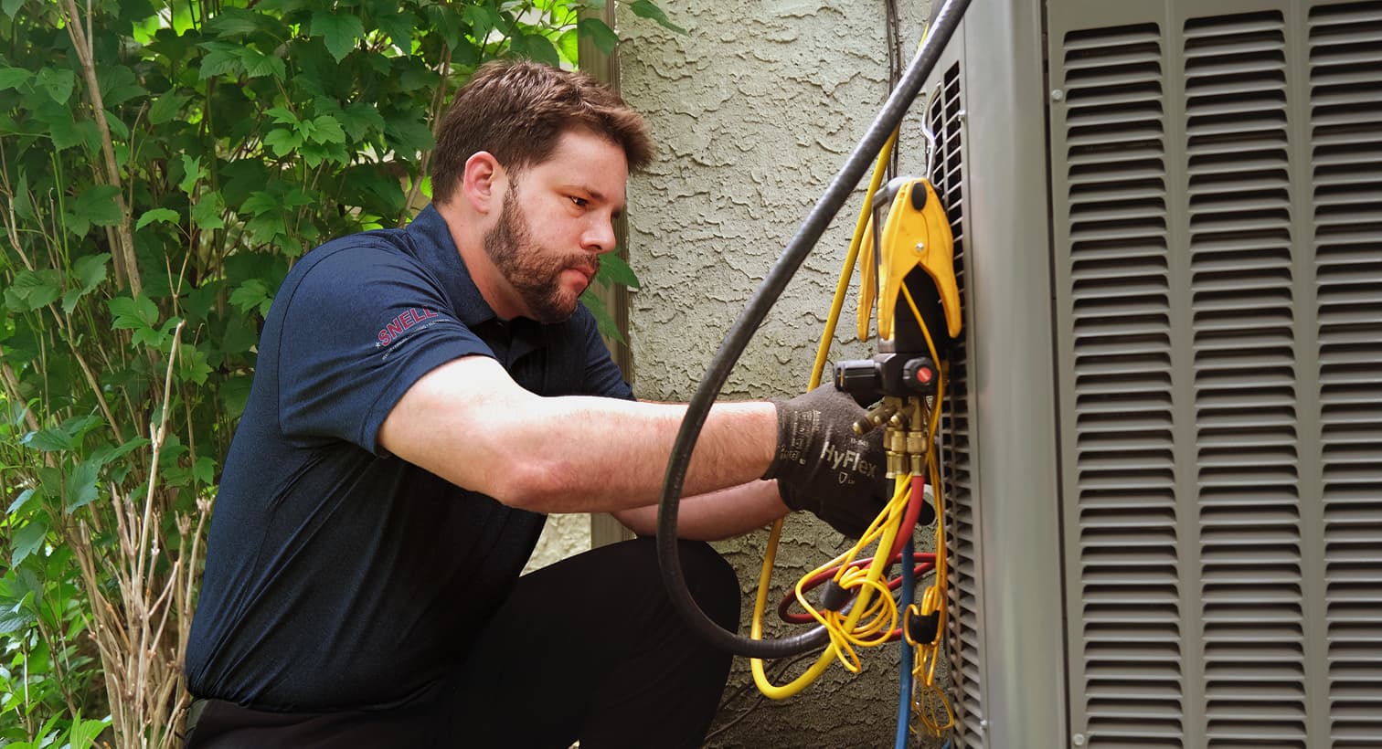A professional Snell HVAC technician inspecting an outdoor central air conditioning unit to provide residential AC repair and diagnostic services.