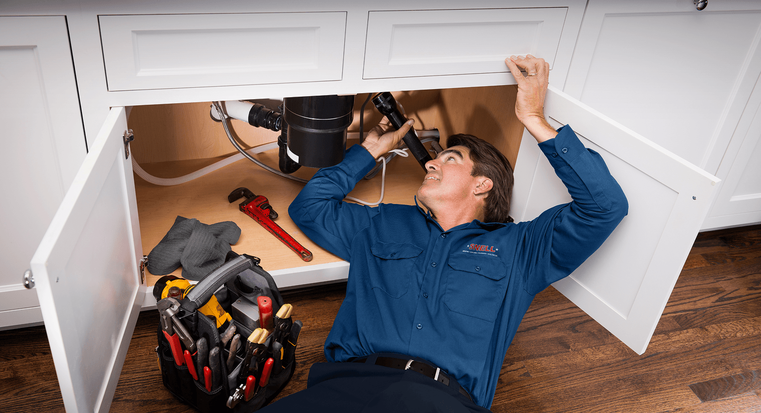 Tech inspecting under sink